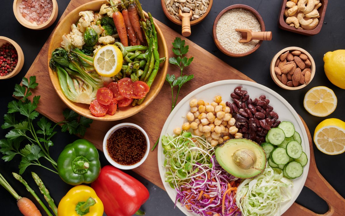 Vegan protein source. Buddha bowl dish, avocado, pepper, tomato, cucumber, red cabbage, chickpea, fresh lettuce salad and walnuts, nuts, beans, . Healthy vegetarian eating, super food. Top view.